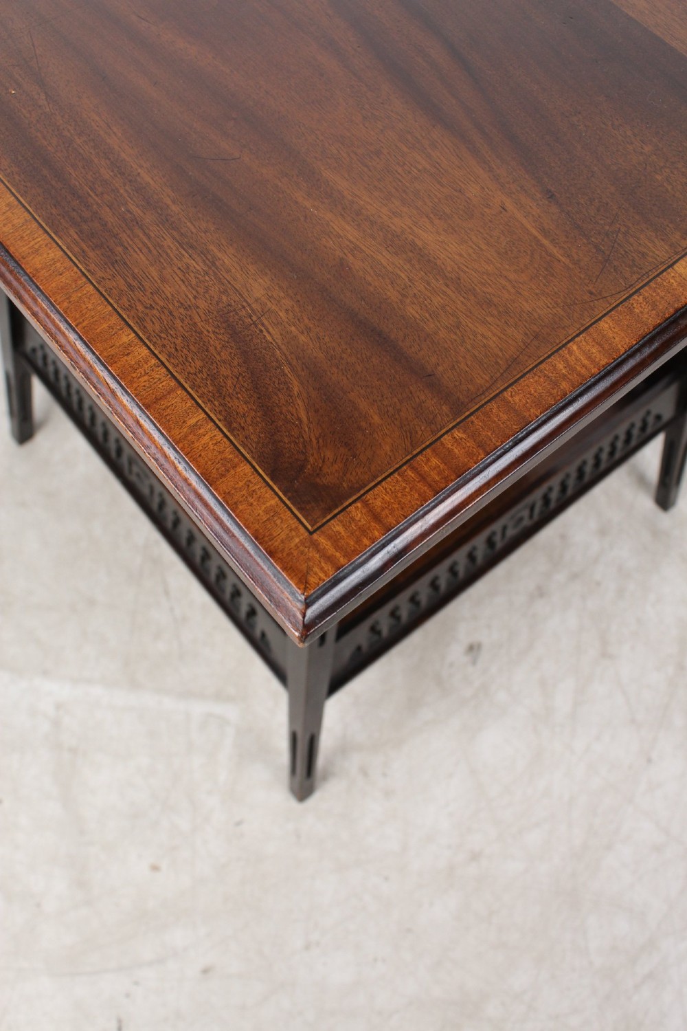 An Edwardian mahogany square side table featuring a central inlaid sunburst medallion, crossbanded border, and a lower undertier shelf with a pierced gallery. View V
