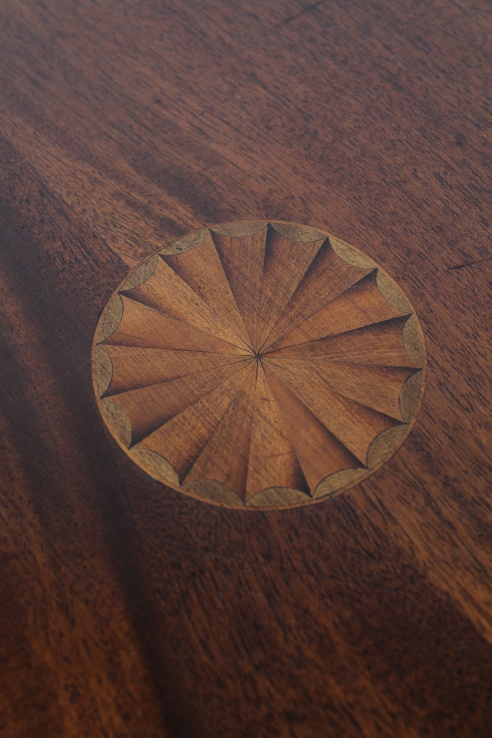 An Edwardian mahogany square side table featuring a central inlaid sunburst medallion, crossbanded border, and a lower undertier shelf with a pierced gallery. View VI