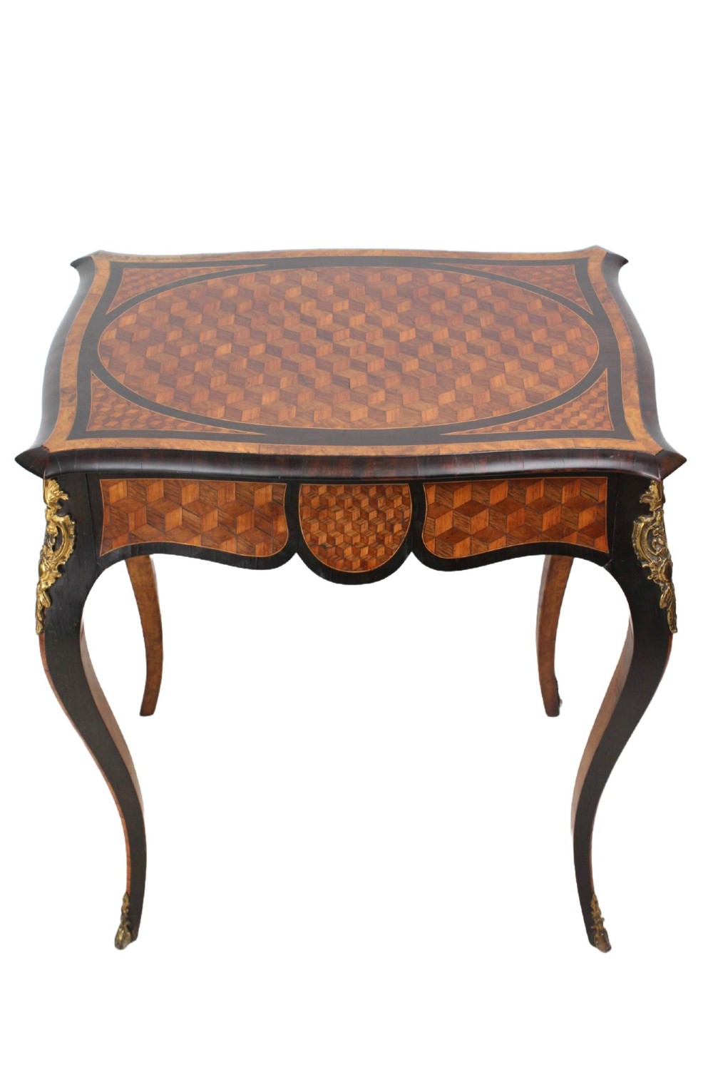 A Victorian Louis XV Revival writing table featuring geometric cube parquetry inlay, serpentine edges, ebonised borders, cabriole legs, and gold-toned bronze mounts.