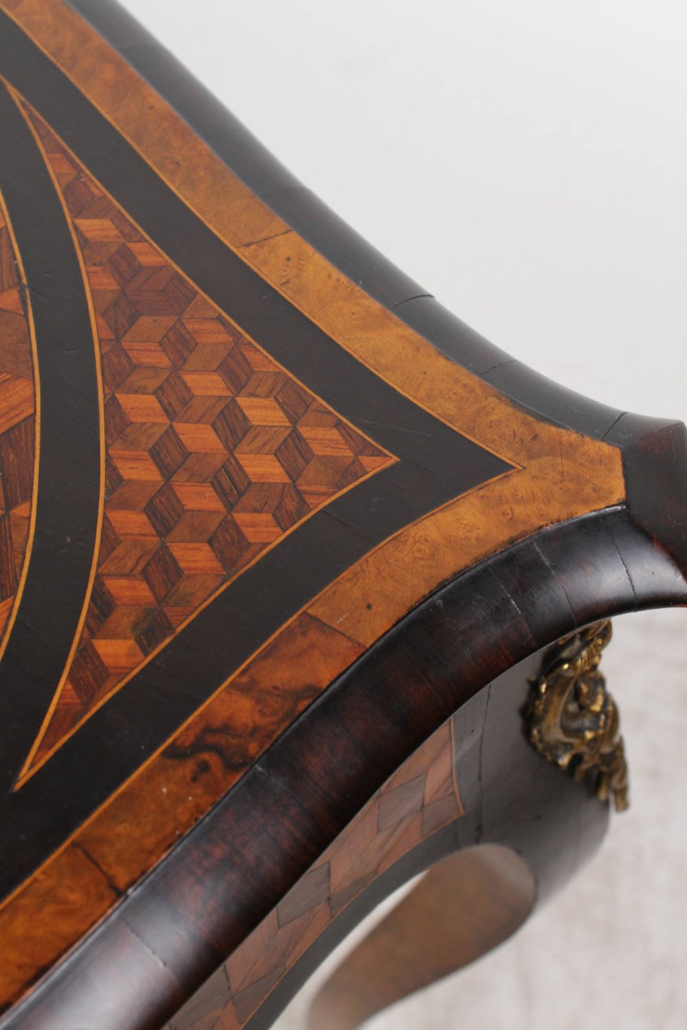 A Victorian Louis XV Revival writing table featuring geometric cube parquetry inlay, serpentine edges, ebonised borders, cabriole legs, and gold-toned bronze mounts. View IX