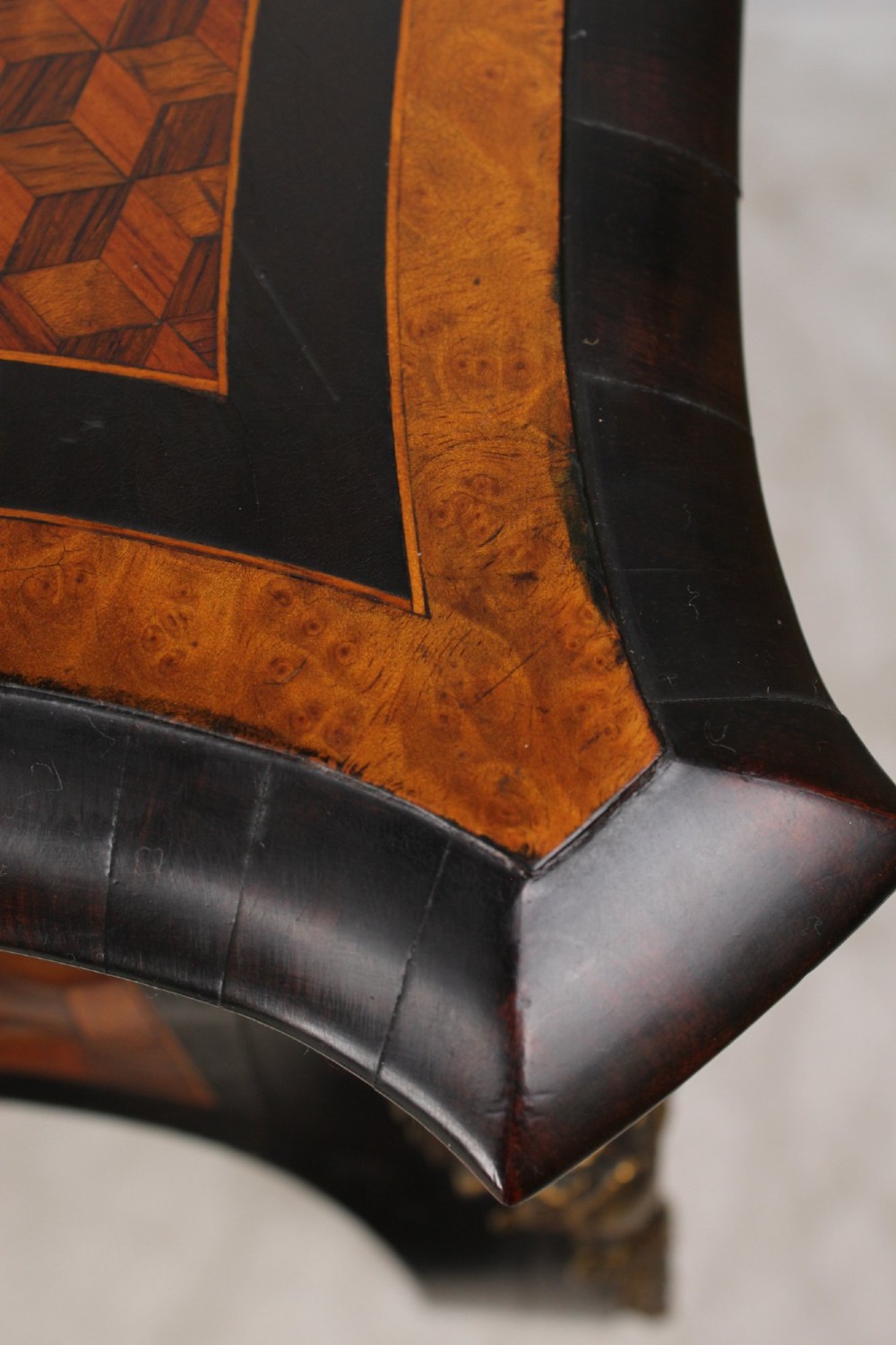 A Victorian Louis XV Revival writing table featuring geometric cube parquetry inlay, serpentine edges, ebonised borders, cabriole legs, and gold-toned bronze mounts. View XI