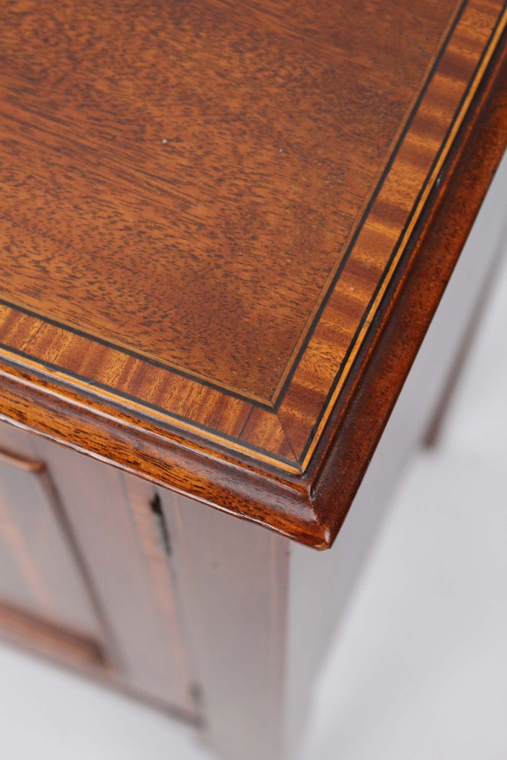 An Edwardian mahogany bedside cabinet featuring satinwood stringing inlay, a single panelled door with a brass handle, and square tapered legs. View VIII