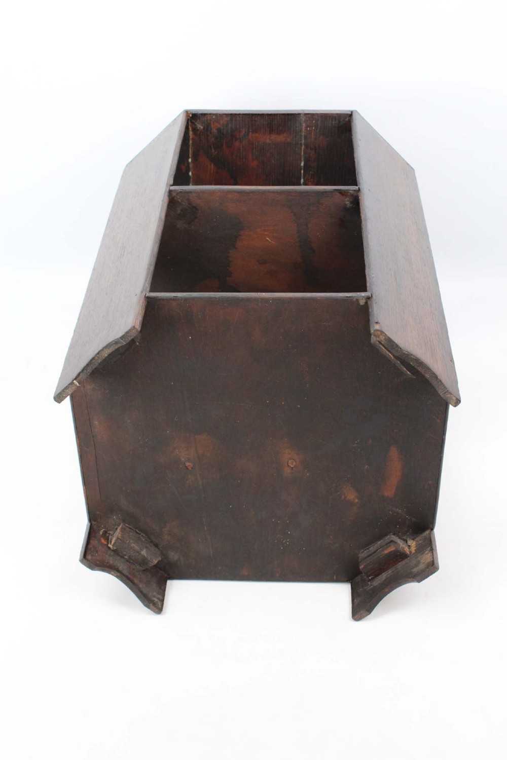 An octagonal dark oak Art Deco style book table featuring three vertical side panels and two open lower shelves. View V