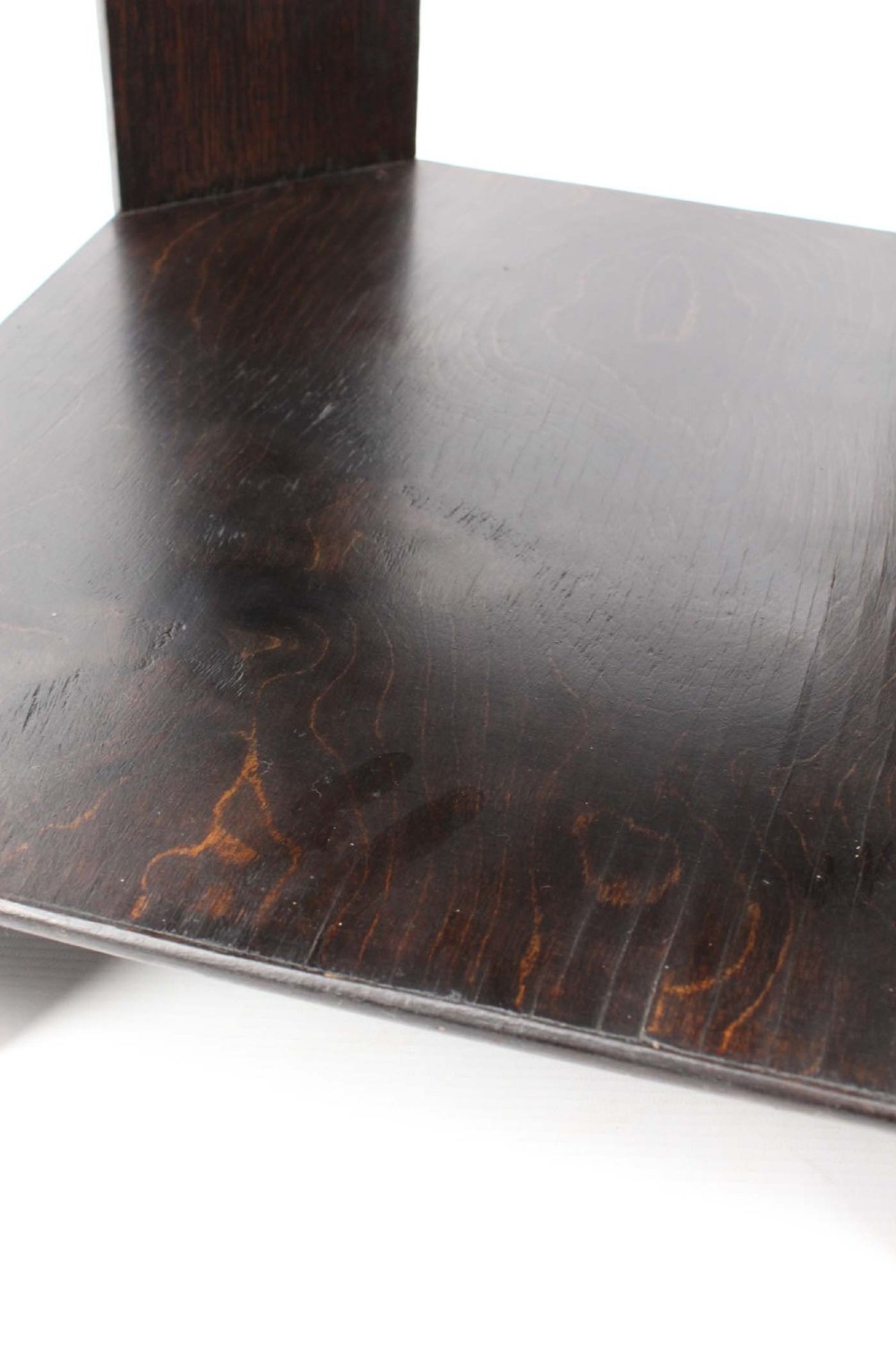 An octagonal dark oak Art Deco style book table featuring three vertical side panels and two open lower shelves. View XI