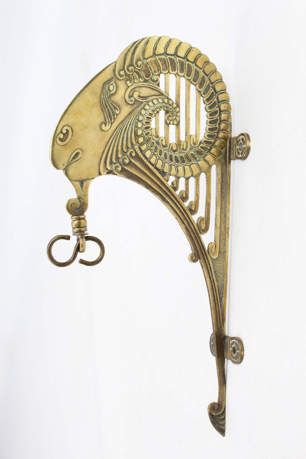 A stylized cast brass Art Deco wall hanging bracket featuring openwork scroll details and a lower swivel hook.