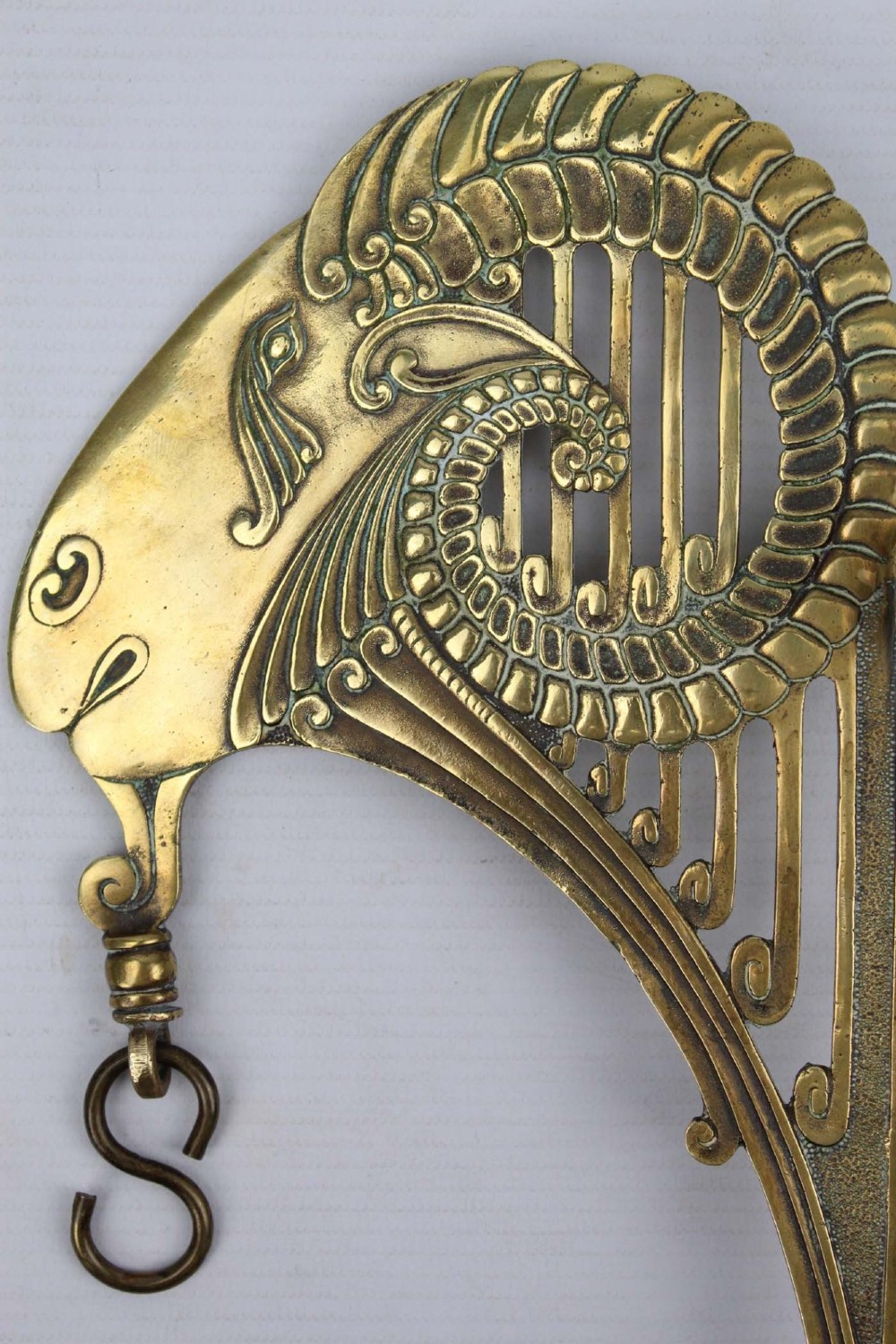 A stylized cast brass Art Deco wall hanging bracket featuring openwork scroll details and a lower swivel hook. View IV
