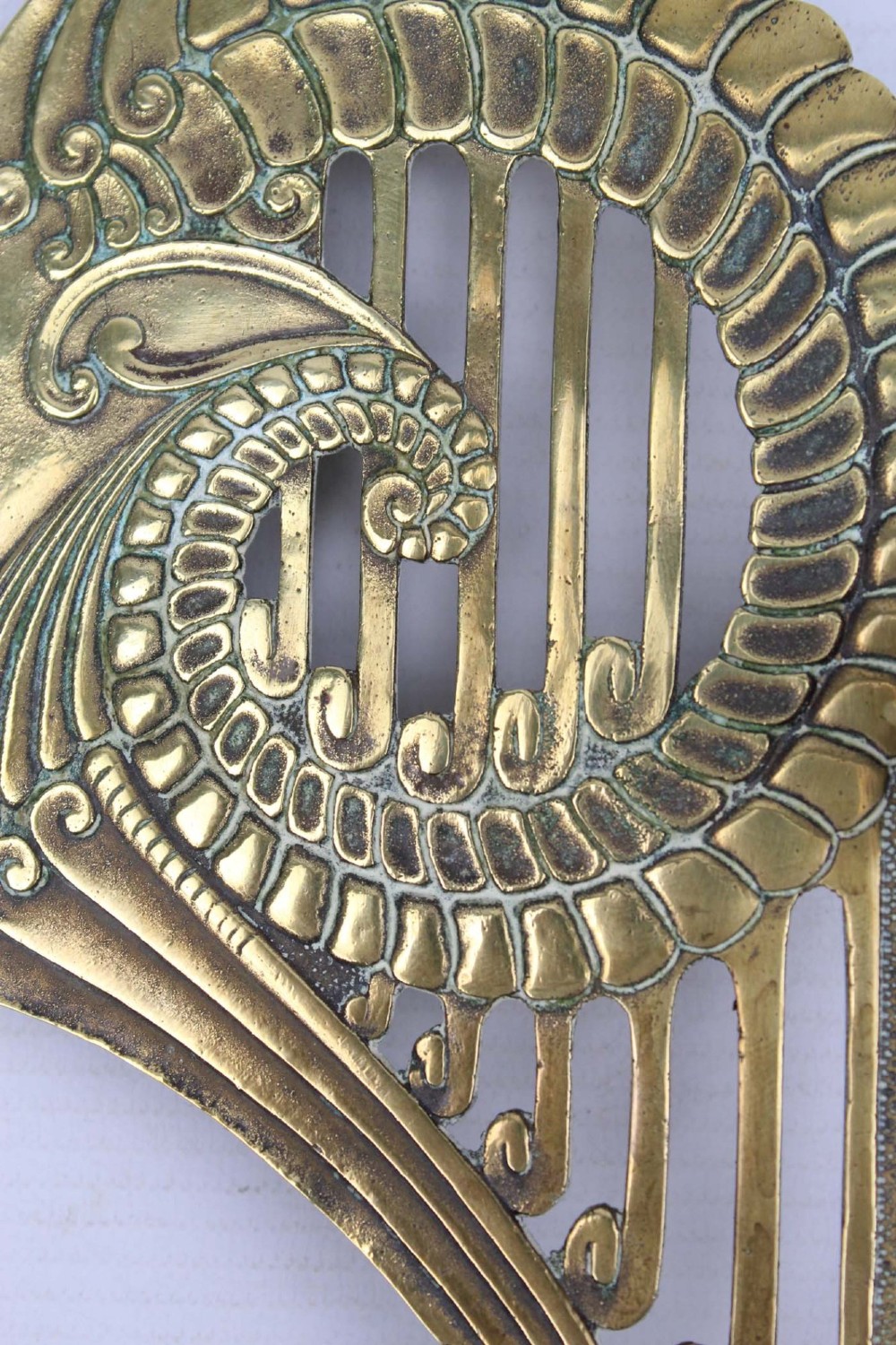 A stylized cast brass Art Deco wall hanging bracket featuring openwork scroll details and a lower swivel hook. View VI
