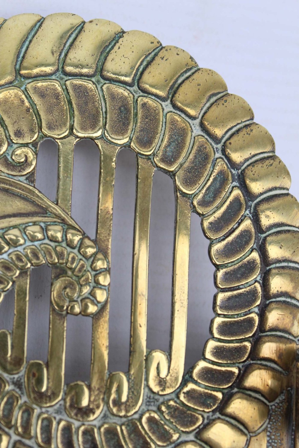 A stylized cast brass Art Deco wall hanging bracket featuring openwork scroll details and a lower swivel hook. View IX