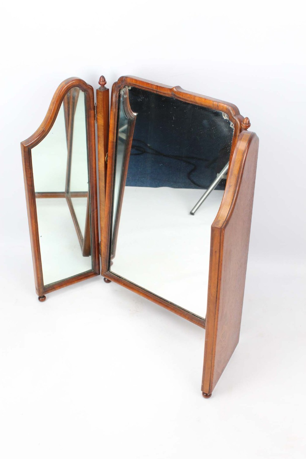 A three-panel walnut triptych dressing table mirror featuring arched side wings, turned finials, and brass hinges. View II