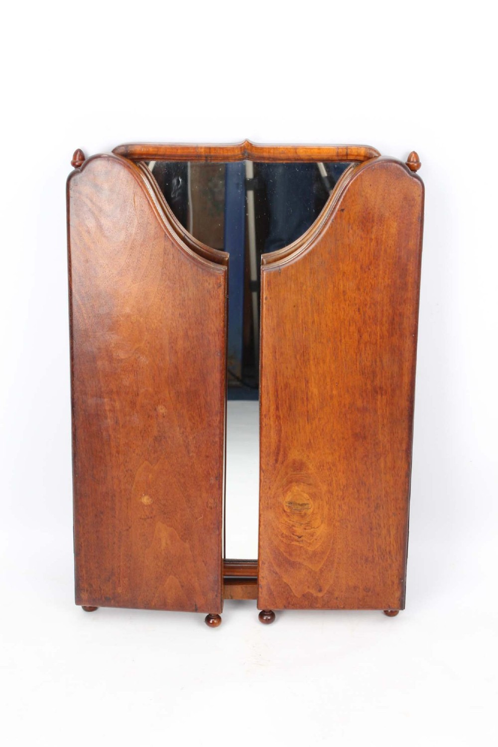 A three-panel walnut triptych dressing table mirror featuring arched side wings, turned finials, and brass hinges. View III