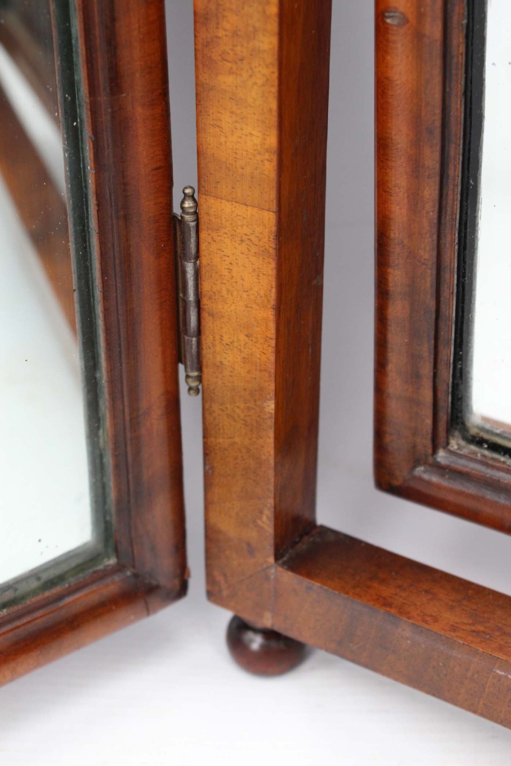 A three-panel walnut triptych dressing table mirror featuring arched side wings, turned finials, and brass hinges. View X