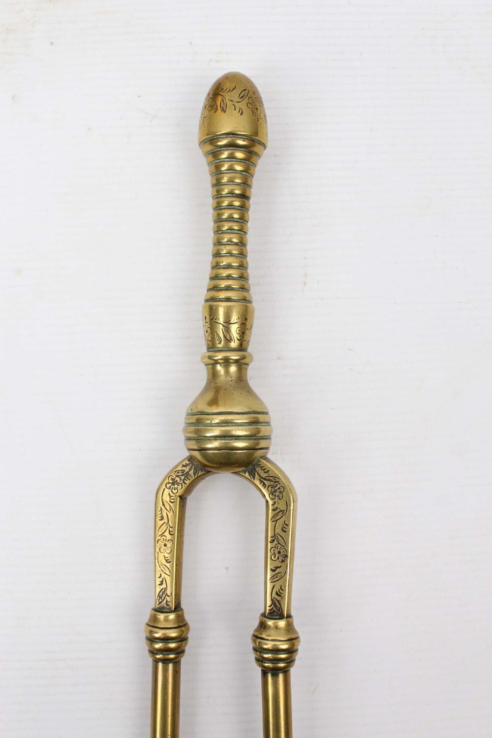A three-piece set of Victorian brass fire tools consisting of a shovel, a poker, and tongs with turned and engraved handles. View II