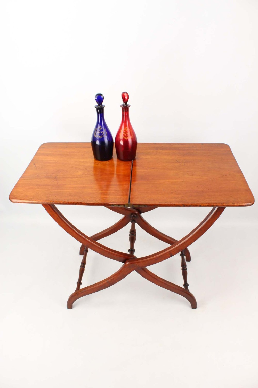 A Victorian mahogany coaching table featuring a rectangular folding top supported by curved X-frame legs and turned stretchers. View II