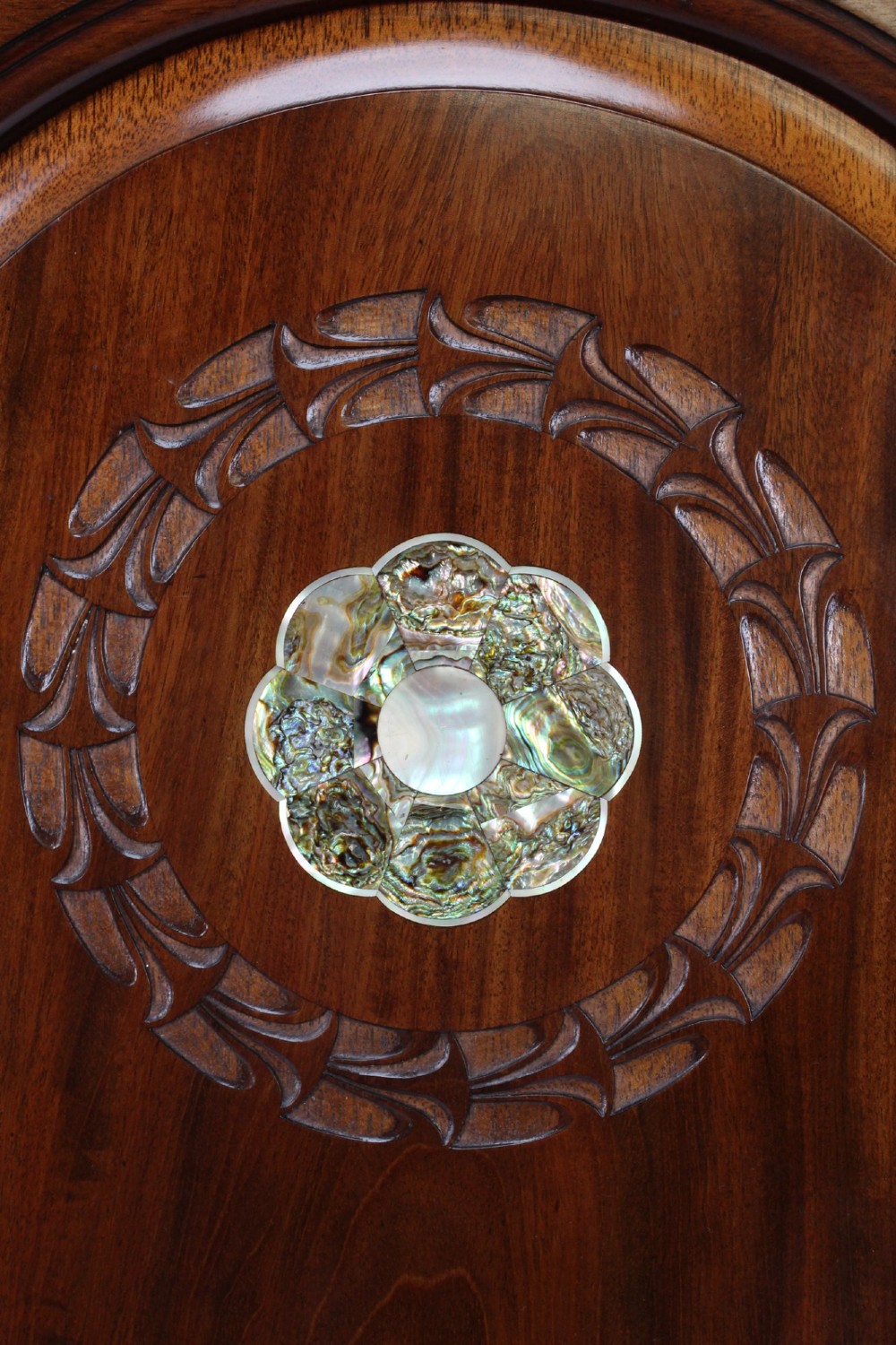 A Victorian walnut single bedstead featuring arched panels, carved circular wreaths, and central mother-of-pearl and abalone shell floral inlays. View VI