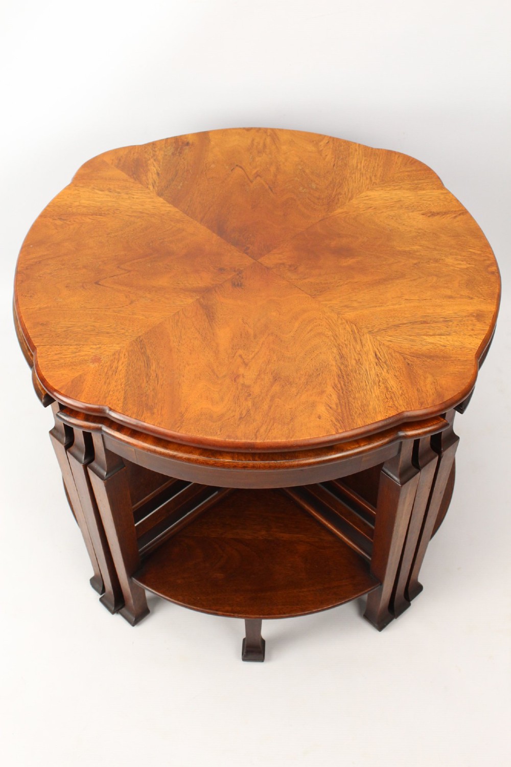 An Art Deco warm brown walnut circular coffee table featuring four sector-shaped nesting side tables stowed underneath. View III