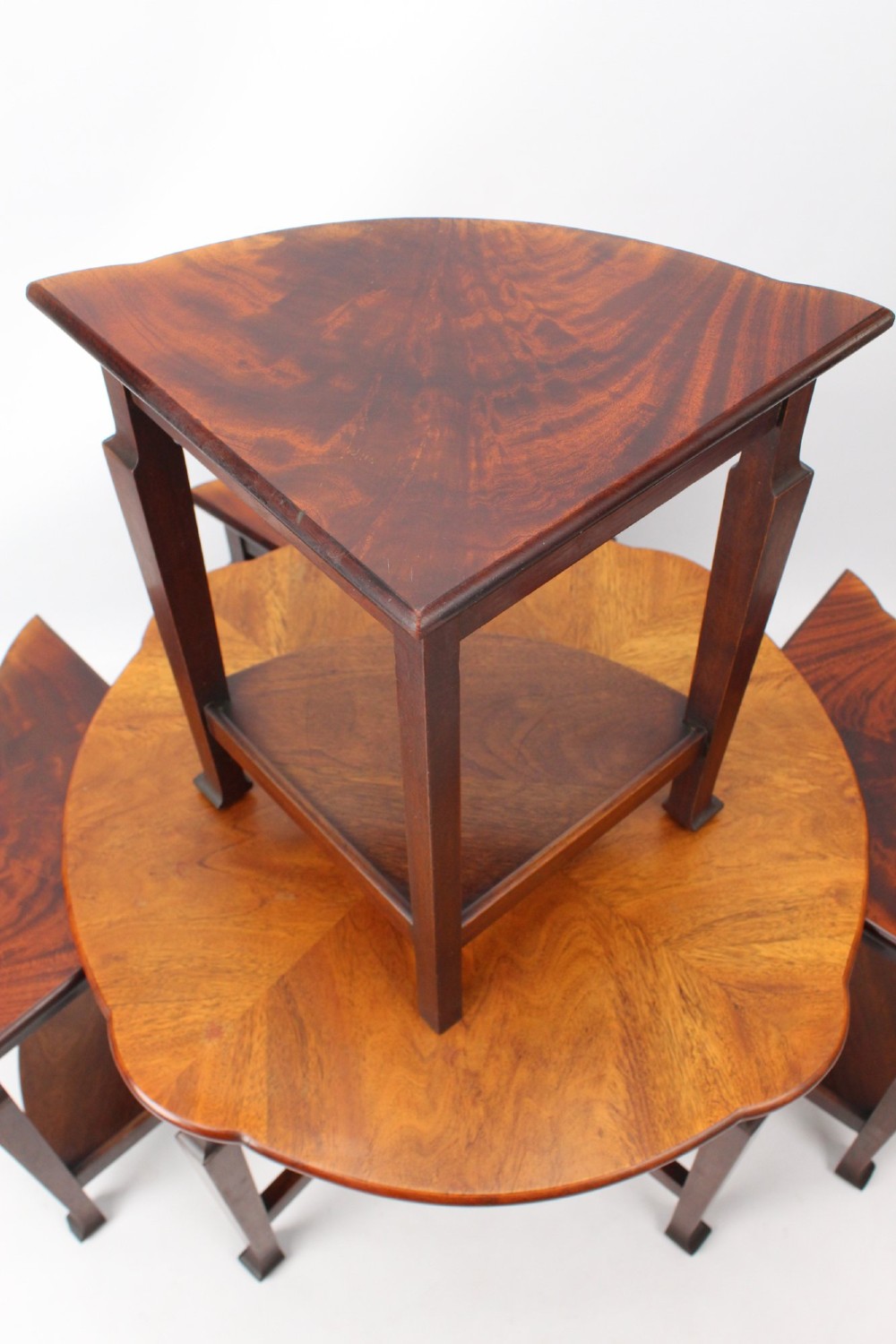 An Art Deco warm brown walnut circular coffee table featuring four sector-shaped nesting side tables stowed underneath. View VIII
