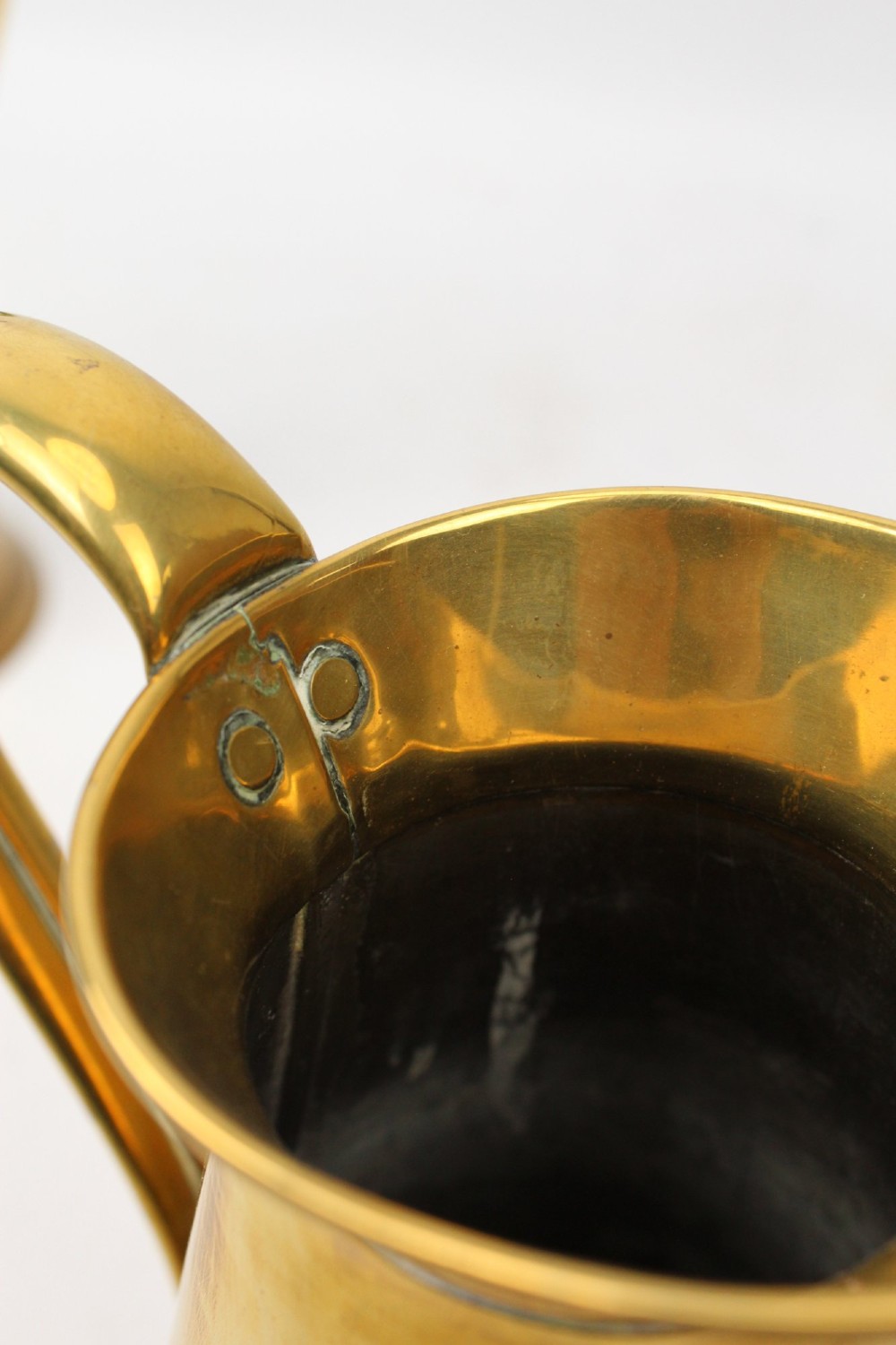 A pair of antique metal jugs, one crafted from repousse copper with brass fittings and a hinged lid alongside a tapered solid brass pitcher. View XII