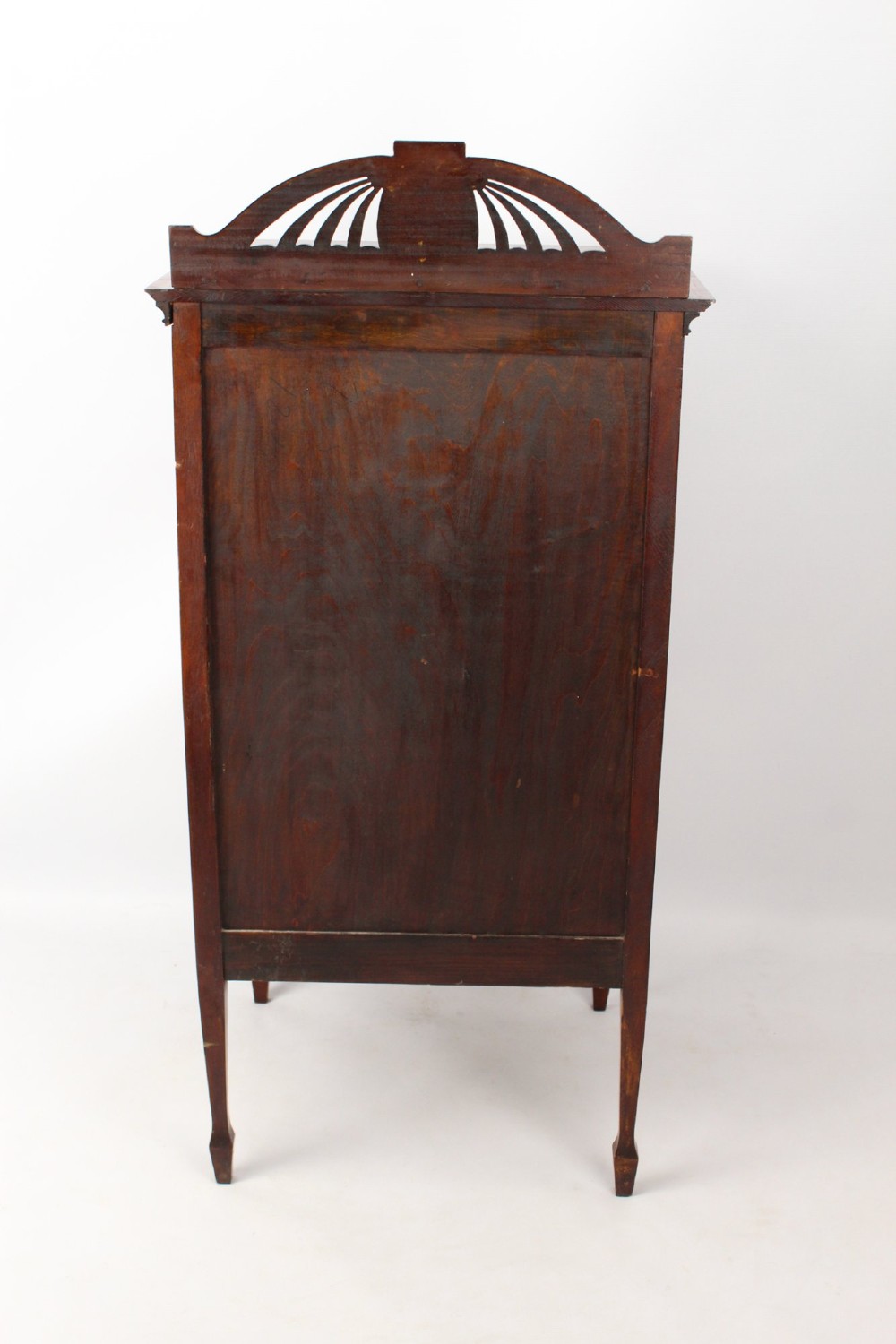 An Edwardian mahogany music cabinet featuring inlaid stringing, three top drawers with brass handles, a two-door lower cupboard, and a carved cresting gallery. View V