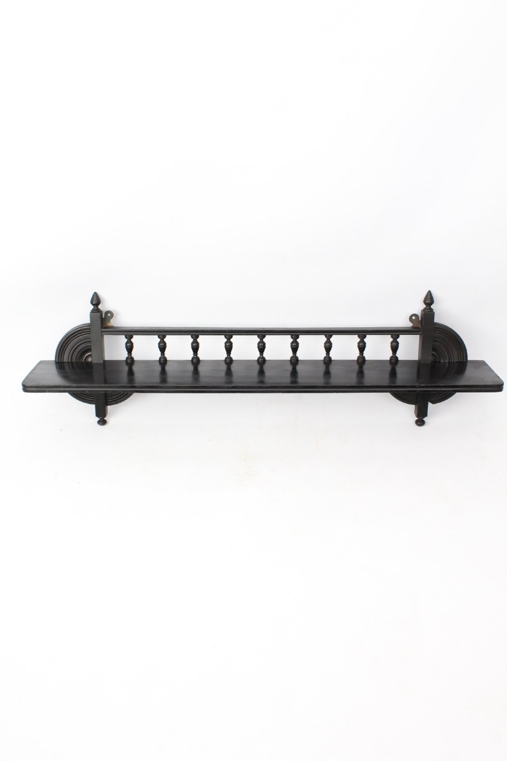An ebonised wooden hanging wall shelf featuring a low spindle balustrade rail, turned finials, and decorative corner mouldings. View II