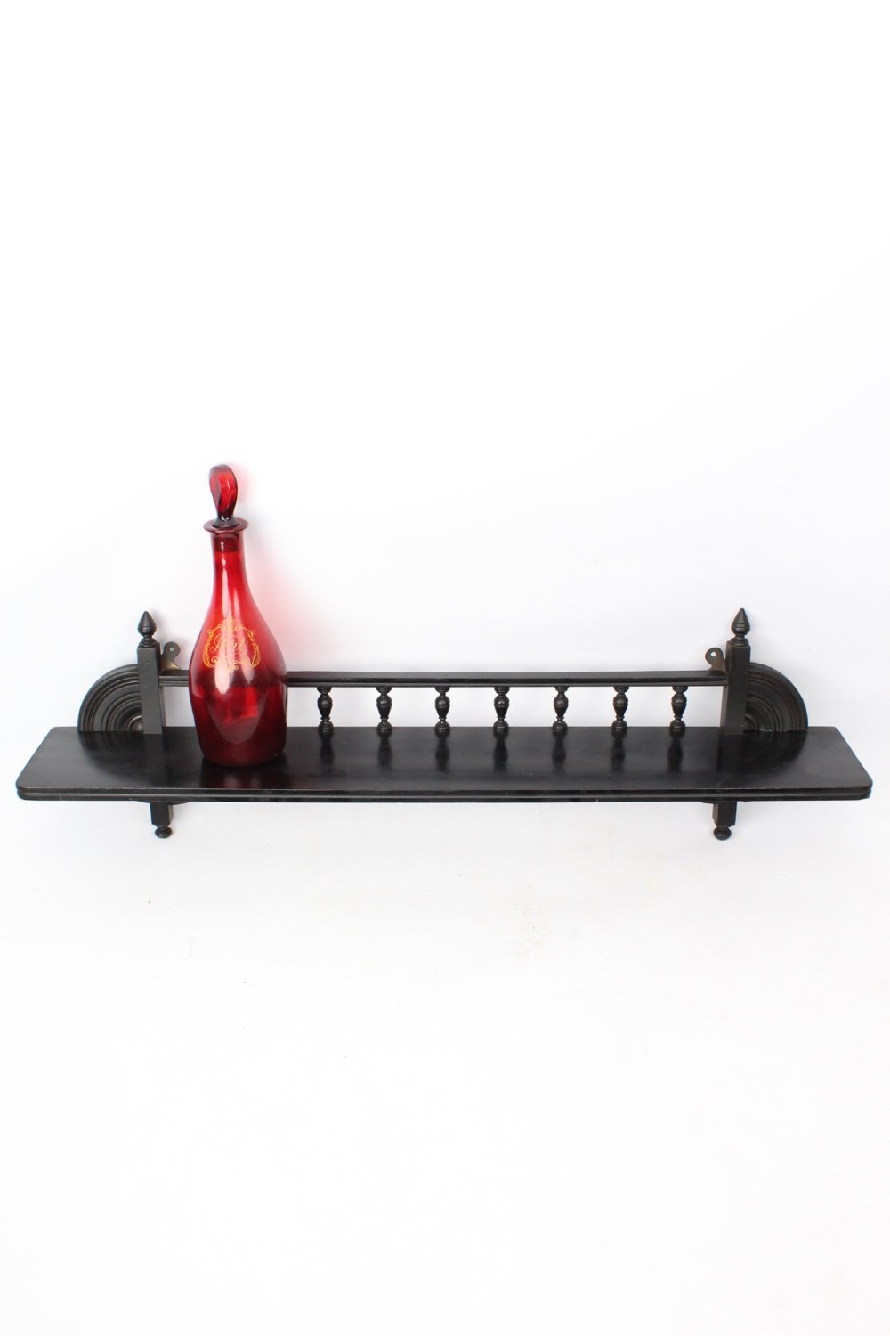 An ebonised wooden hanging wall shelf featuring a low spindle balustrade rail, turned finials, and decorative corner mouldings. View III