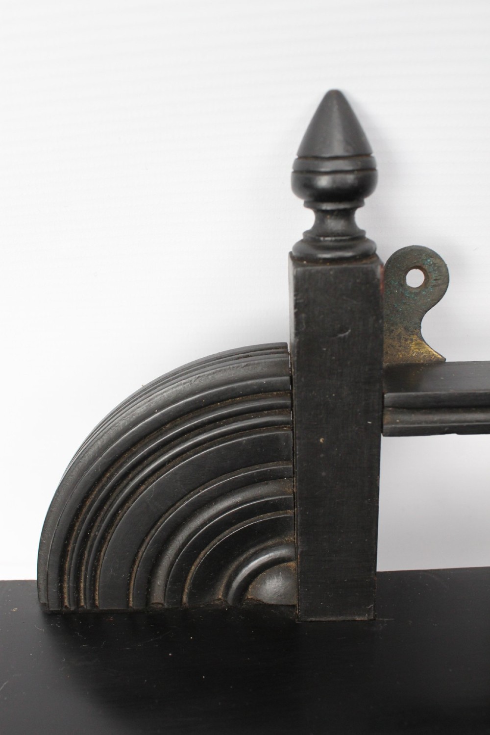 An ebonised wooden hanging wall shelf featuring a low spindle balustrade rail, turned finials, and decorative corner mouldings. View VI