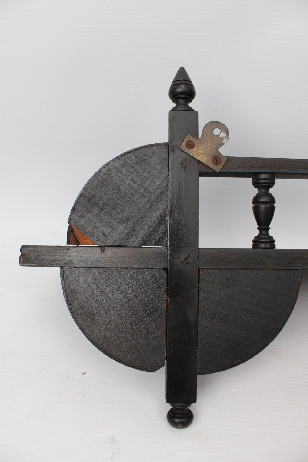 An ebonised wooden hanging wall shelf featuring a low spindle balustrade rail, turned finials, and decorative corner mouldings. View XI
