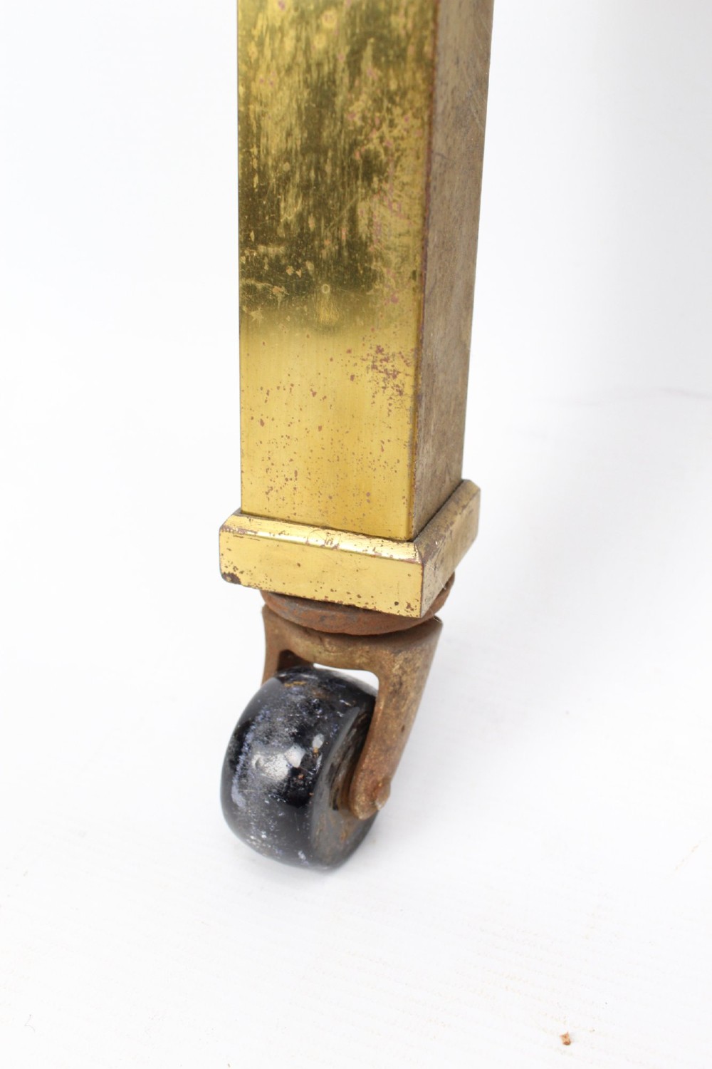 A Victorian brass single bed frame featuring a gently curved top rail, vertical spindles, turned finials, and original wheel castors. View VIII