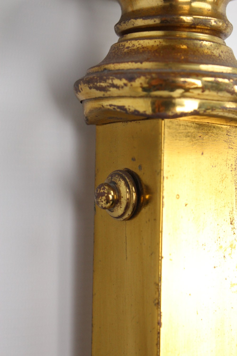 A Victorian brass single bed frame featuring a gently curved top rail, vertical spindles, turned finials, and original wheel castors. View XII