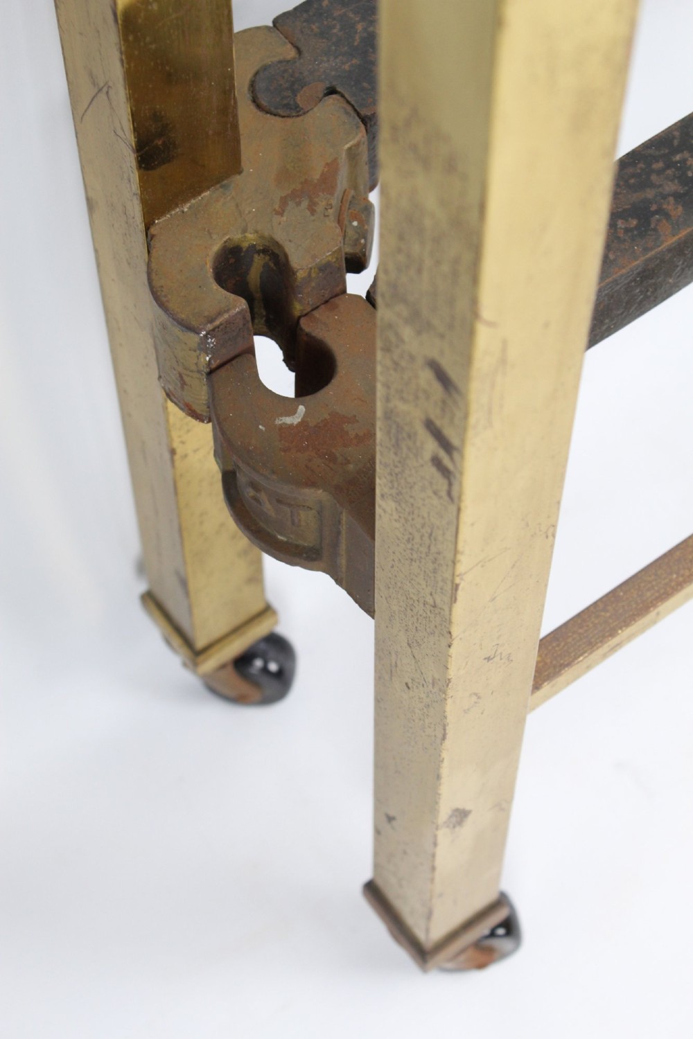 A Victorian brass single bed frame featuring a gently curved top rail, vertical spindles, turned finials, and original wheel castors. View XIII