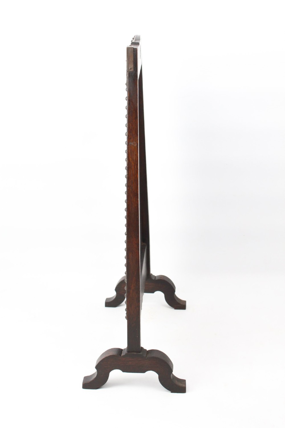 An Edwardian Arts and Crafts fire screen constructed from carved oak and warm brown leather featuring brass studwork and a central oval motif. View III