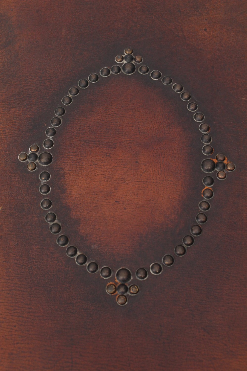 An Edwardian Arts and Crafts fire screen constructed from carved oak and warm brown leather featuring brass studwork and a central oval motif. View VII