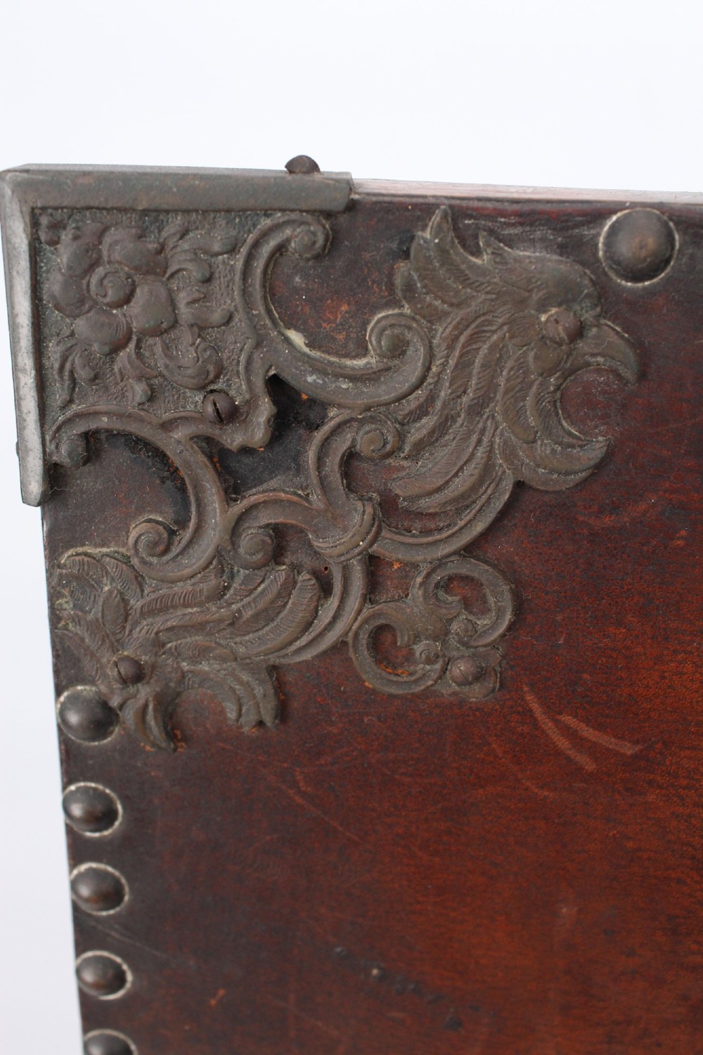 An Edwardian Arts and Crafts fire screen constructed from carved oak and warm brown leather featuring brass studwork and a central oval motif. View XII