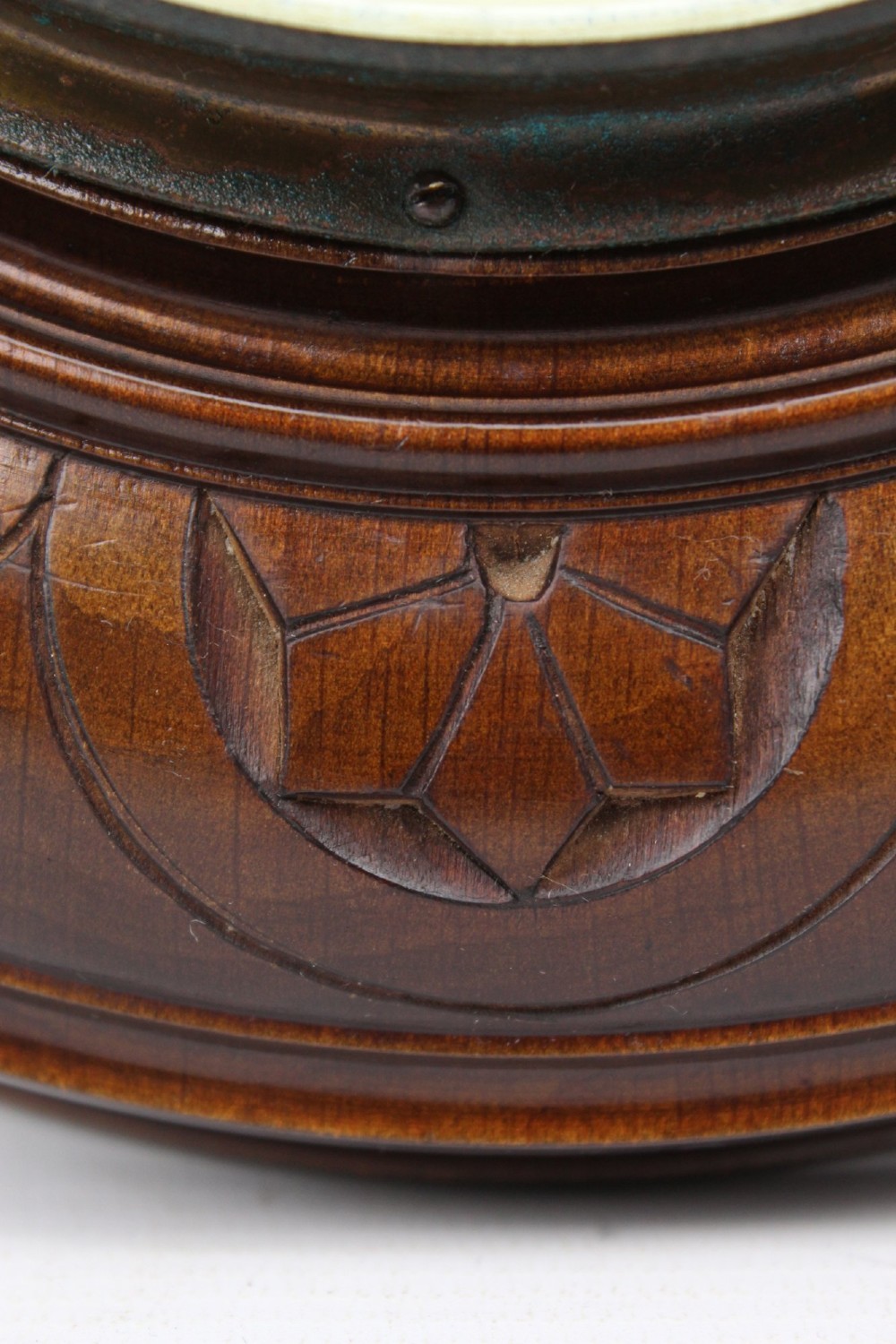 A circular Victorian walnut wall barometer featuring a carved wooden border, a brass hanging ring, and an exposed brass skeleton movement within an enamel dial. View IX