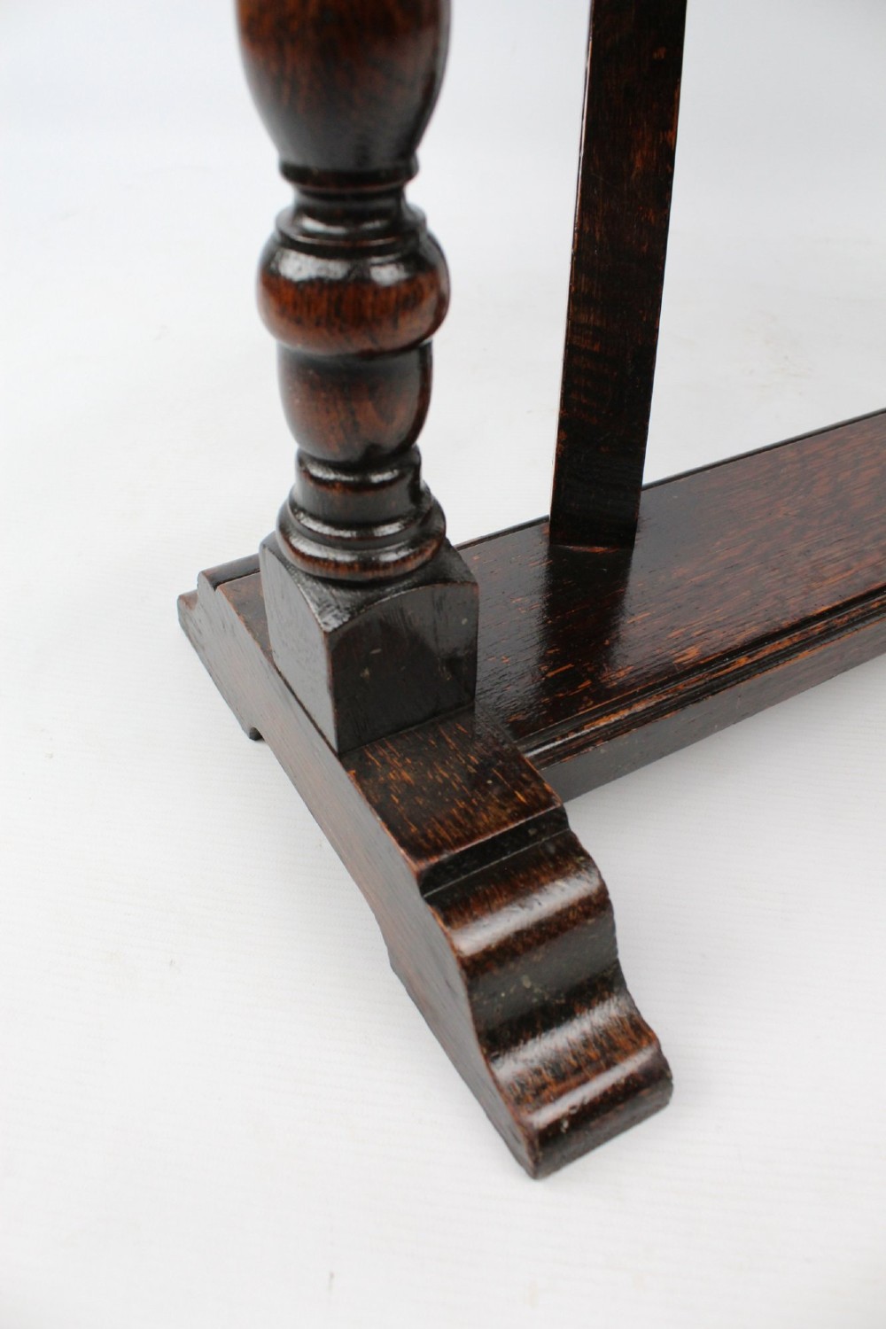 A dark oak drop-leaf coffee table featuring hinged side flaps, turned legs, and a sturdy trestle base. View VIII