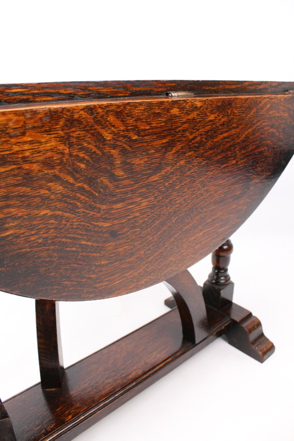 A dark oak drop-leaf coffee table featuring hinged side flaps, turned legs, and a sturdy trestle base. View IX