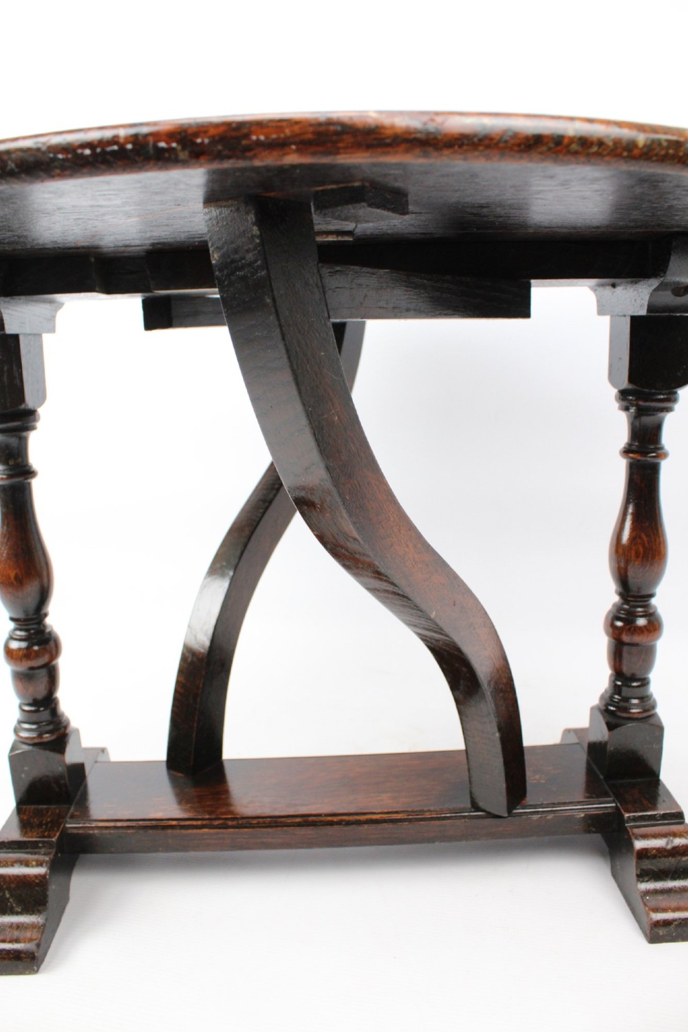 A dark oak drop-leaf coffee table featuring hinged side flaps, turned legs, and a sturdy trestle base. View X