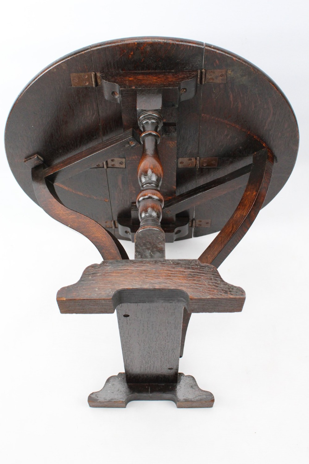 A dark oak drop-leaf coffee table featuring hinged side flaps, turned legs, and a sturdy trestle base. View XIII
