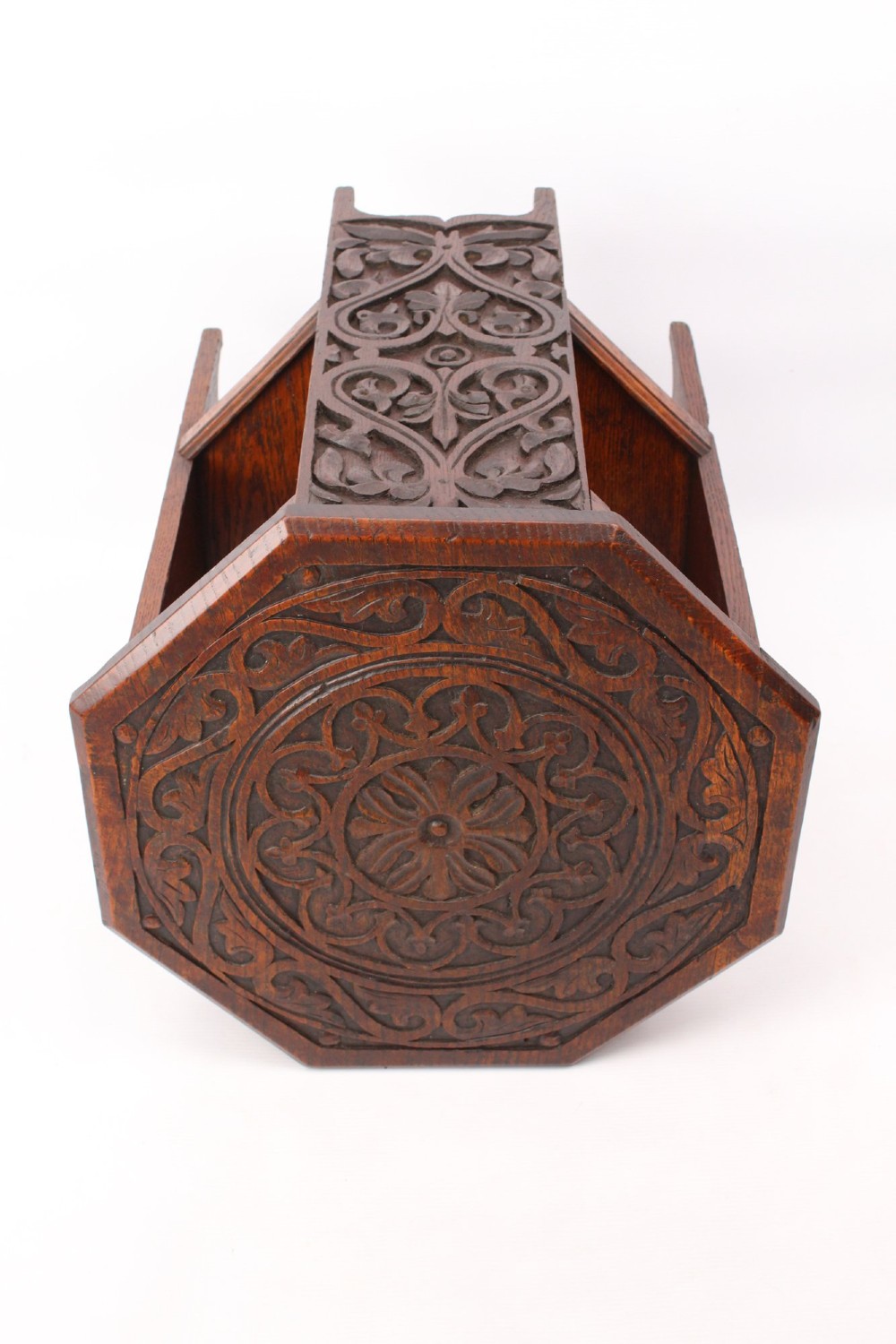 An Edwardian hexagonal dark oak side table featuring intricate relief carving on the top surface and side panels. View IV