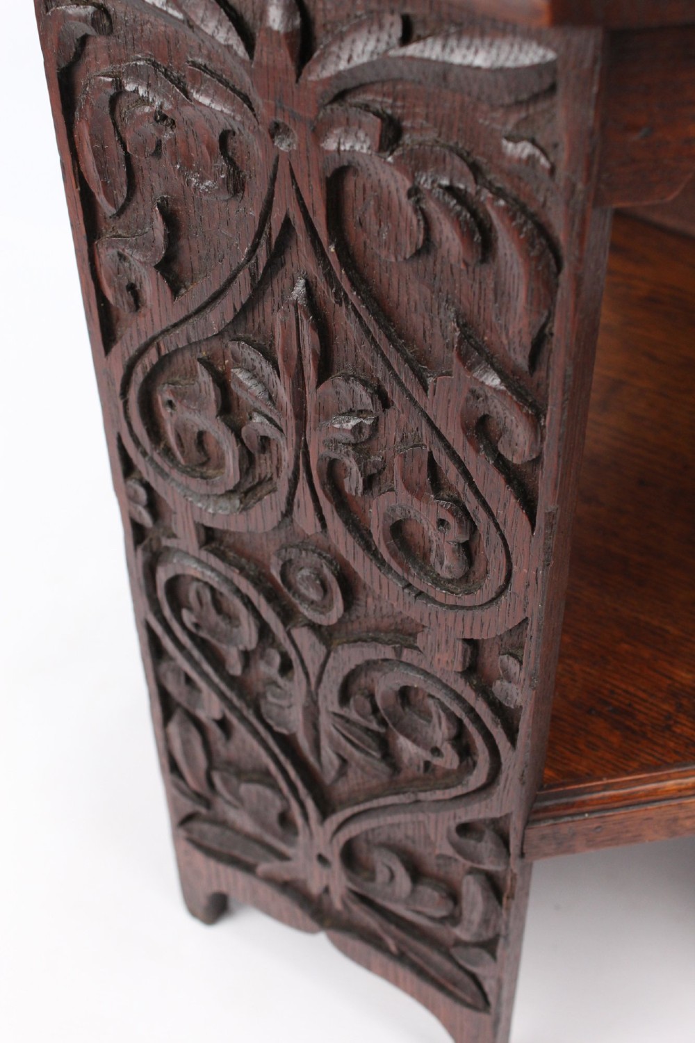 An Edwardian hexagonal dark oak side table featuring intricate relief carving on the top surface and side panels. View V