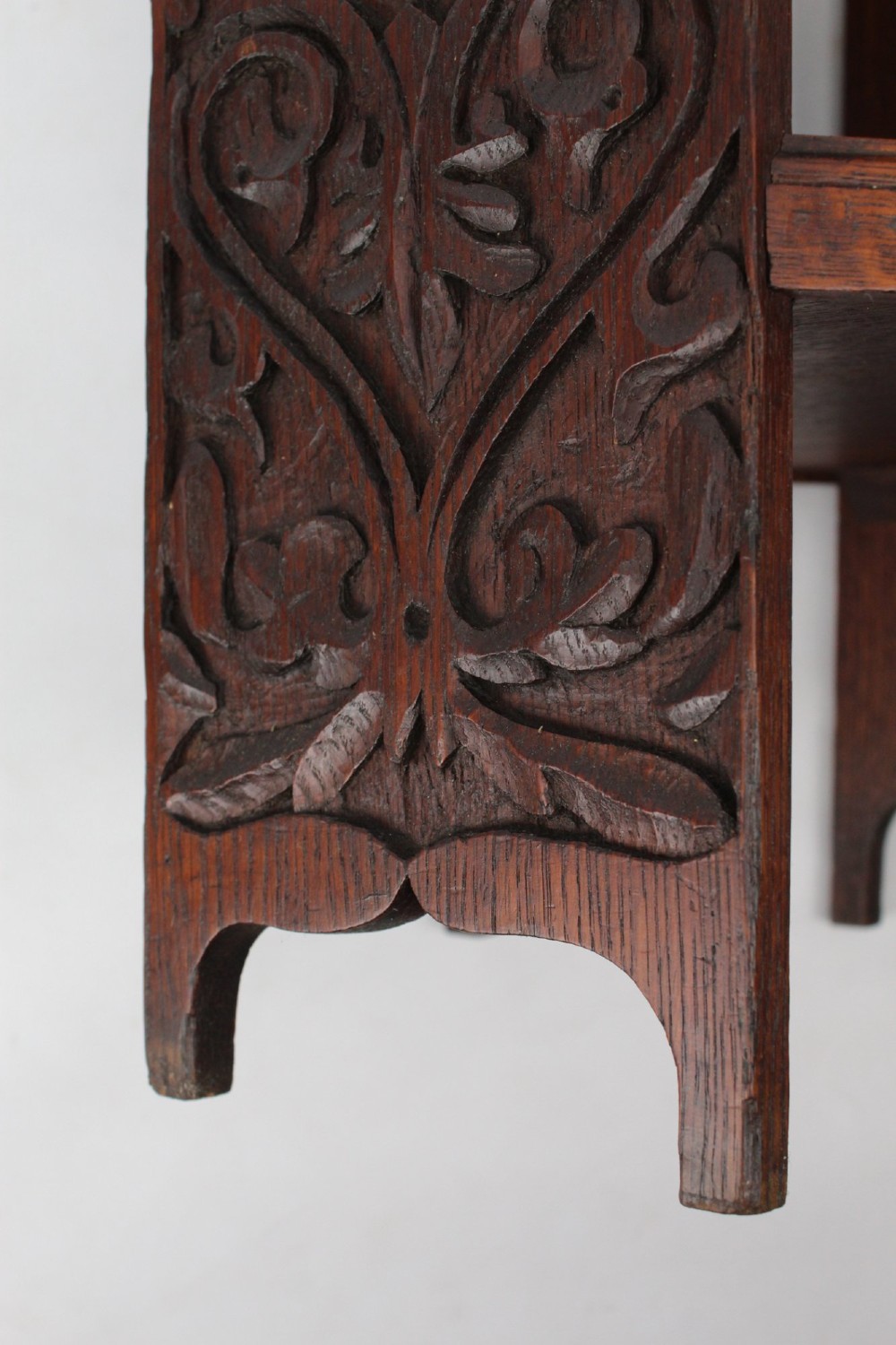An Edwardian hexagonal dark oak side table featuring intricate relief carving on the top surface and side panels. View VI