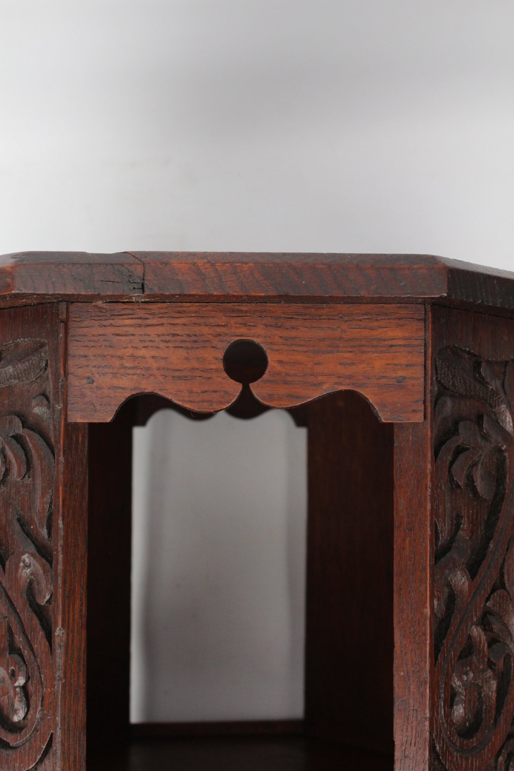 An Edwardian hexagonal dark oak side table featuring intricate relief carving on the top surface and side panels. View VII