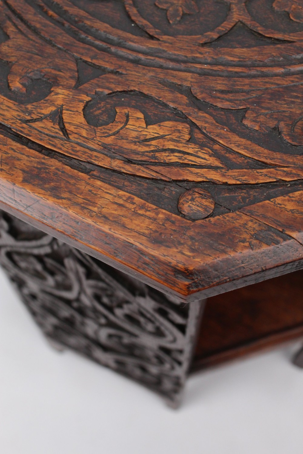An Edwardian hexagonal dark oak side table featuring intricate relief carving on the top surface and side panels. View VIII