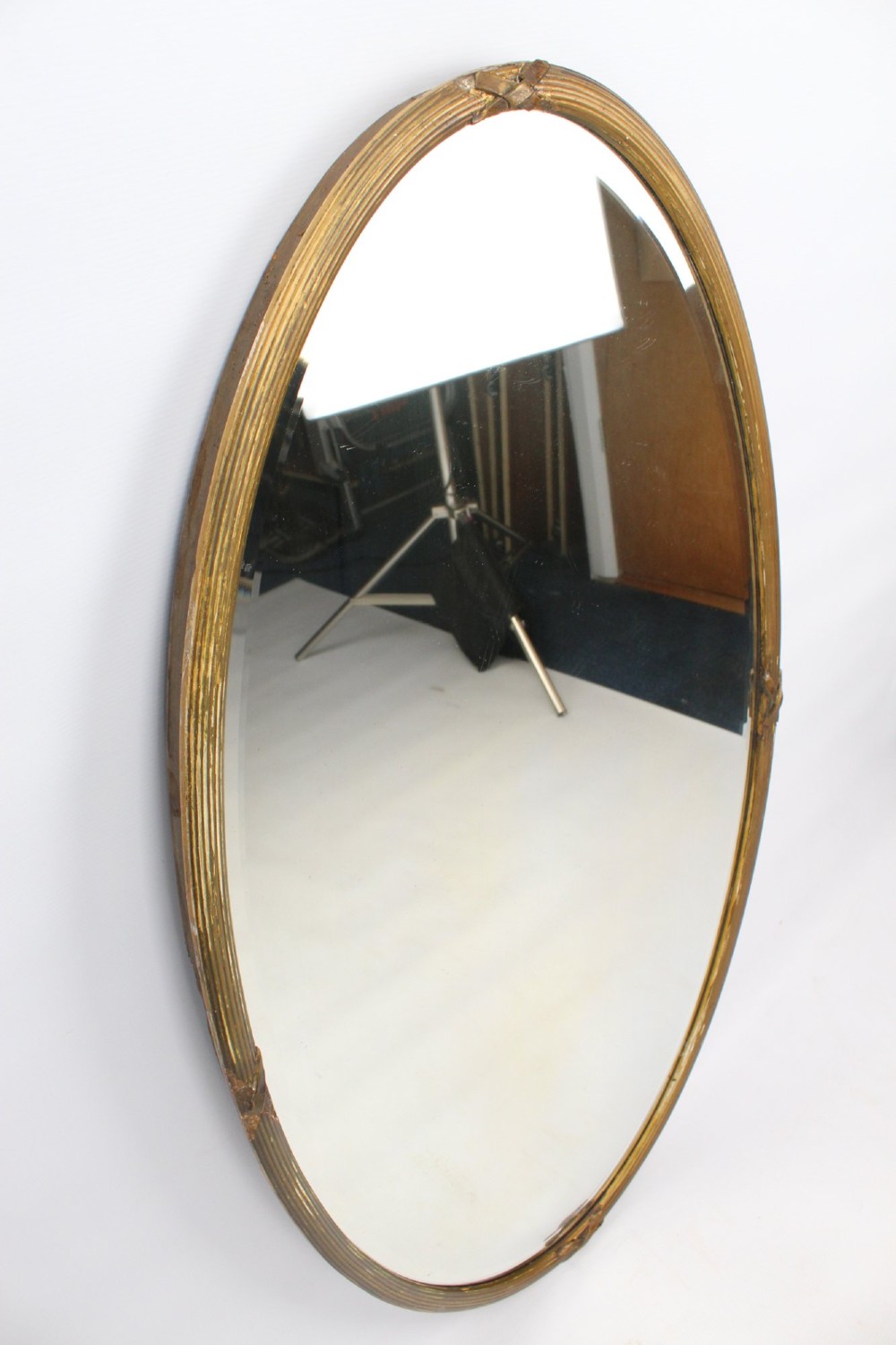A large Victorian oval wall mirror featuring a gilded reeded frame with decorative cross-ribbon accents at four points. View III