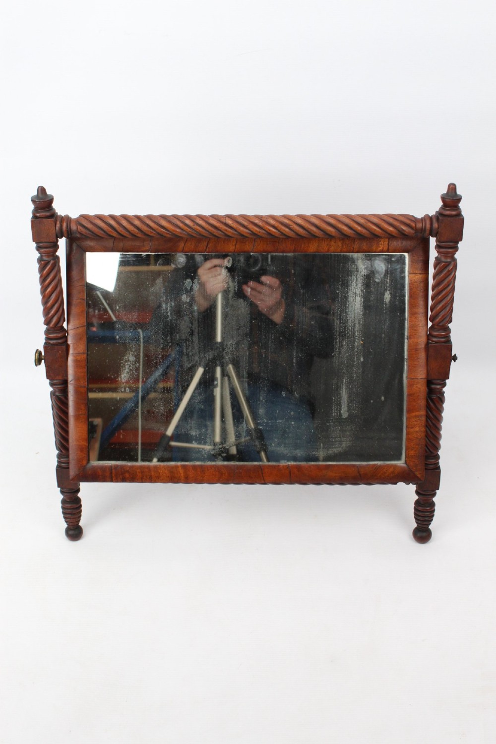 An antique Regency mahogany toilet mirror featuring a swivelling rectangular glass frame supported by rope-twist turned pillars with finials. View II