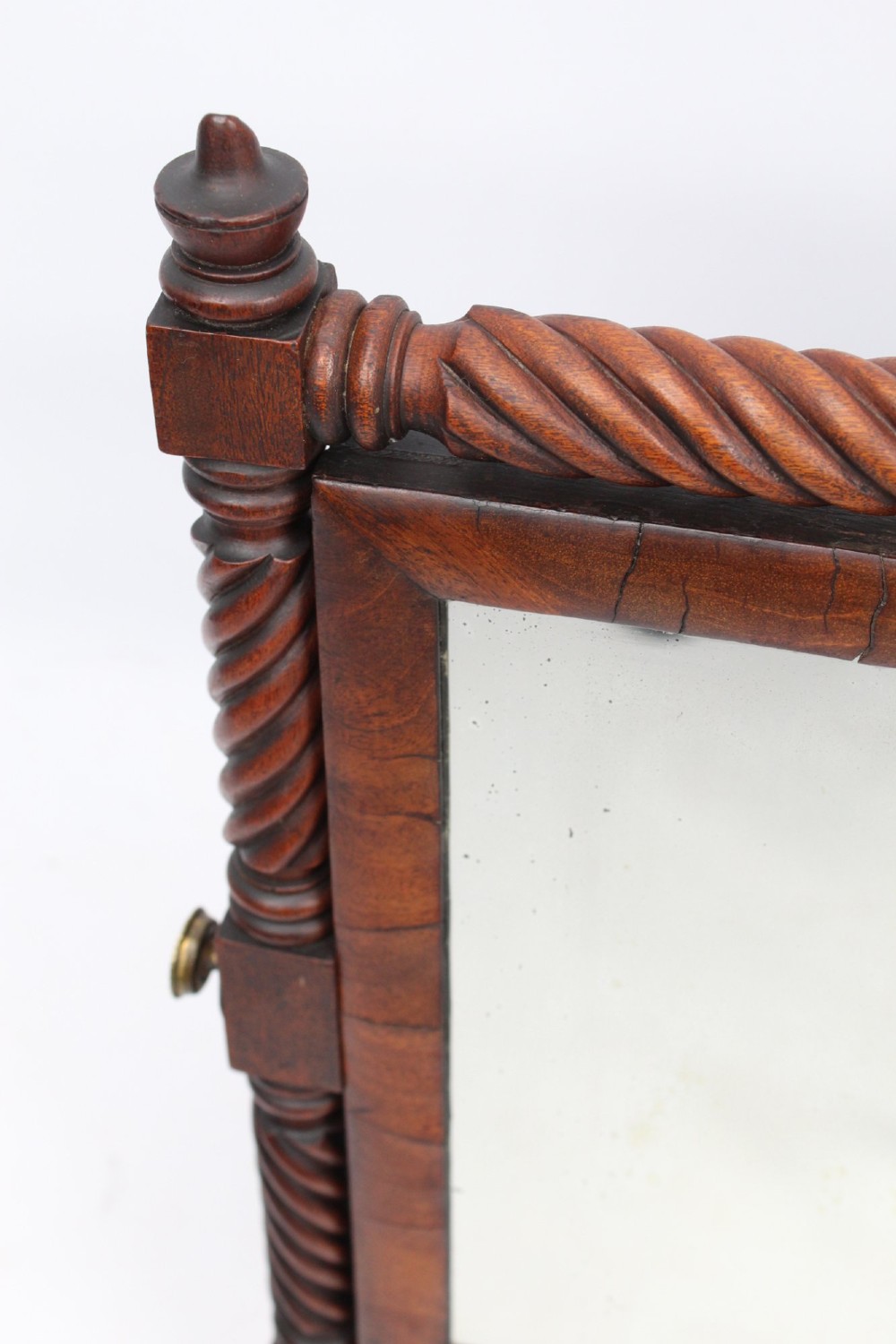 An antique Regency mahogany toilet mirror featuring a swivelling rectangular glass frame supported by rope-twist turned pillars with finials. View VII