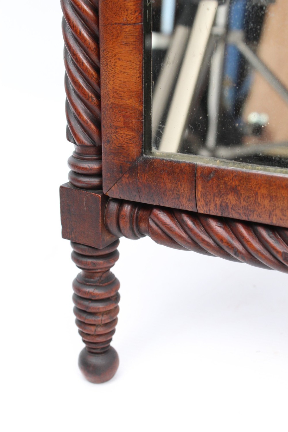 An antique Regency mahogany toilet mirror featuring a swivelling rectangular glass frame supported by rope-twist turned pillars with finials. View X