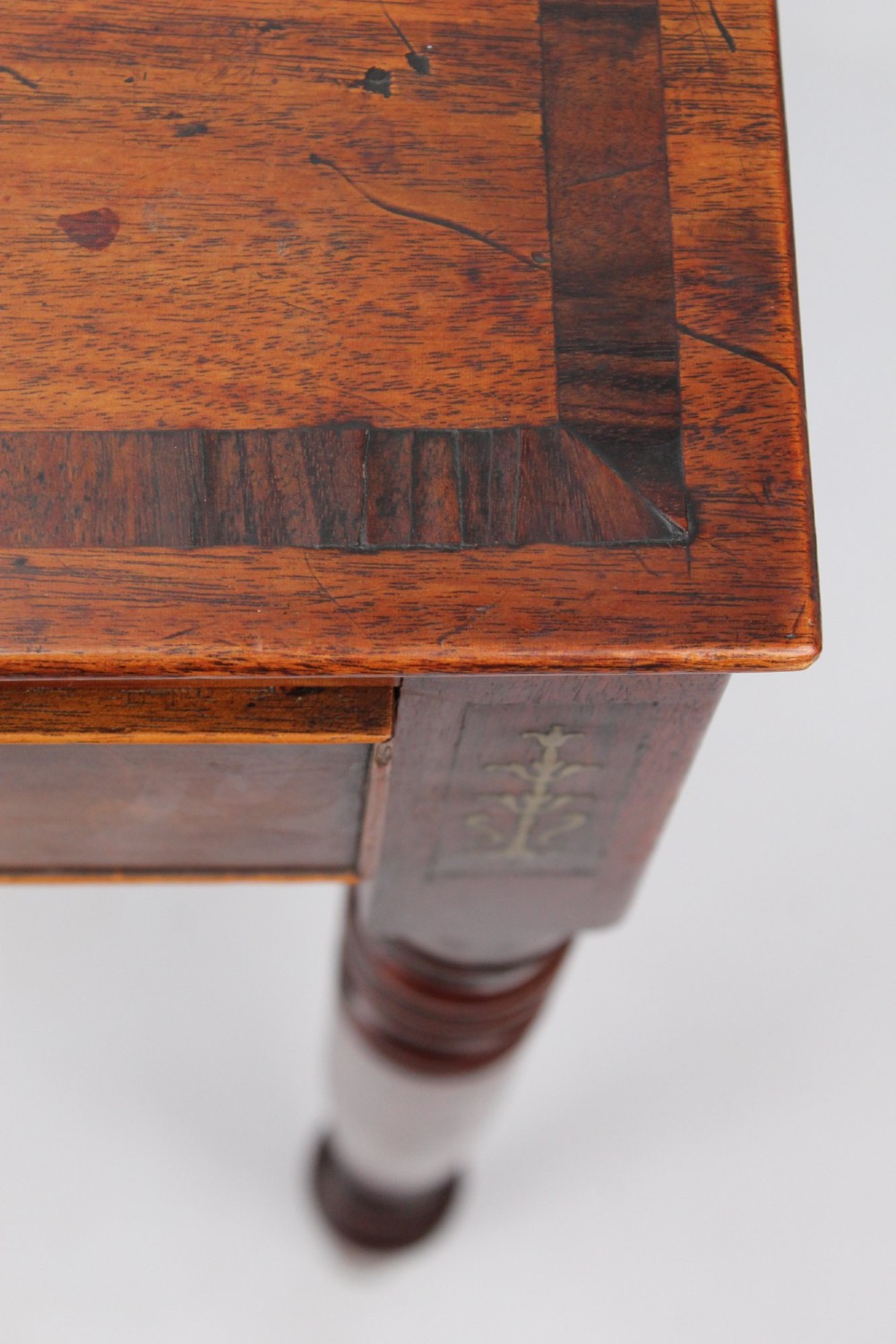 A Regency mahogany writing desk featuring brass inlaid corner stiles, two frieze drawers with wooden knobs, and turned legs. View IX