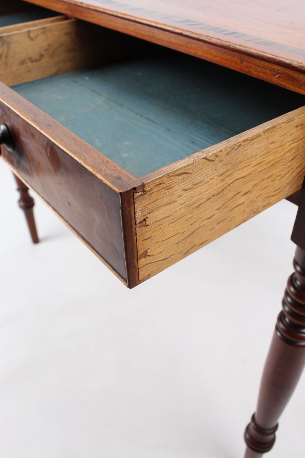 A Regency mahogany writing desk featuring brass inlaid corner stiles, two frieze drawers with wooden knobs, and turned legs. View XI