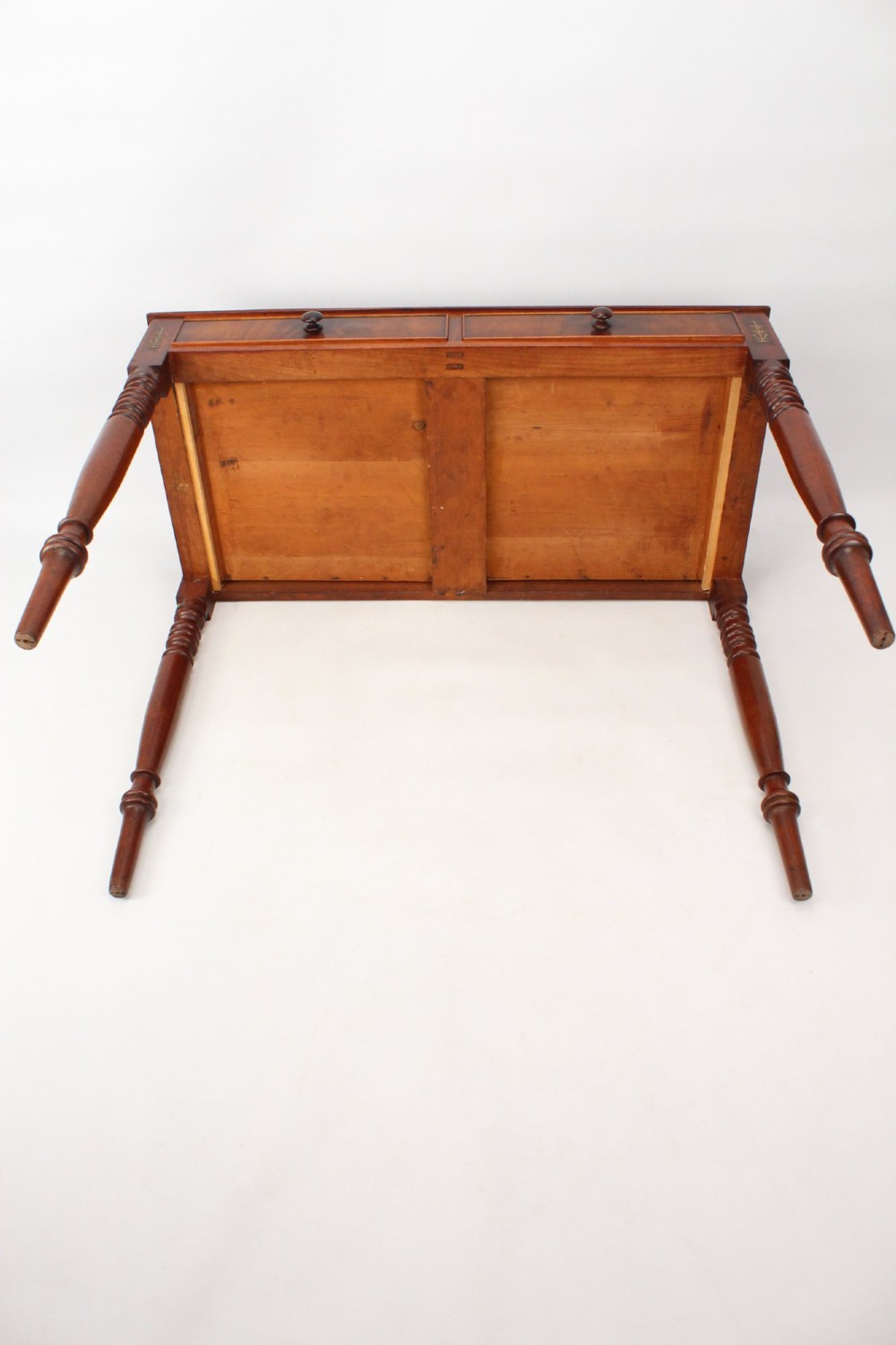A Regency mahogany writing desk featuring brass inlaid corner stiles, two frieze drawers with wooden knobs, and turned legs. View XIII