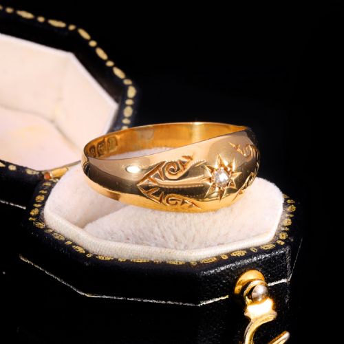 fig 2. An 18ct yellow gold Victorian band ring featuring a starburst-set diamond surrounded by hand-carved scroll engraving and visible internal hallmarks.